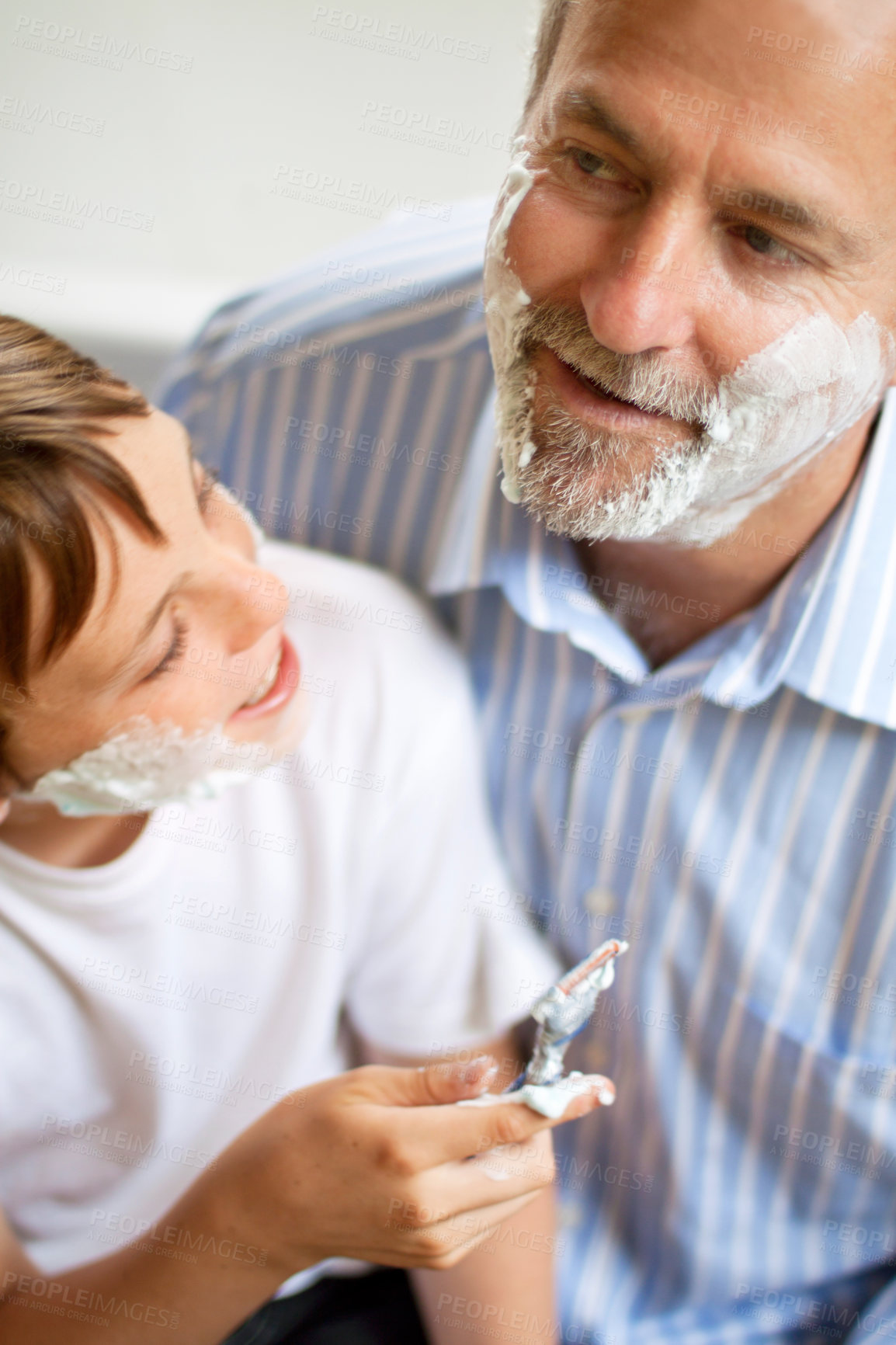 Buy stock photo Family, father and son learning to shave in the bathroom of a home together closeup from above. Razor, shaving cream and a man teaching his boy child about skincare or grooming while bonding