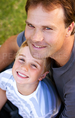 Buy stock photo Portrait, happy man and son sitting on grass, cute bonding together with care and love from above. Fun, father and child on ground in backyard with smile, trust and support with parent and young boy.