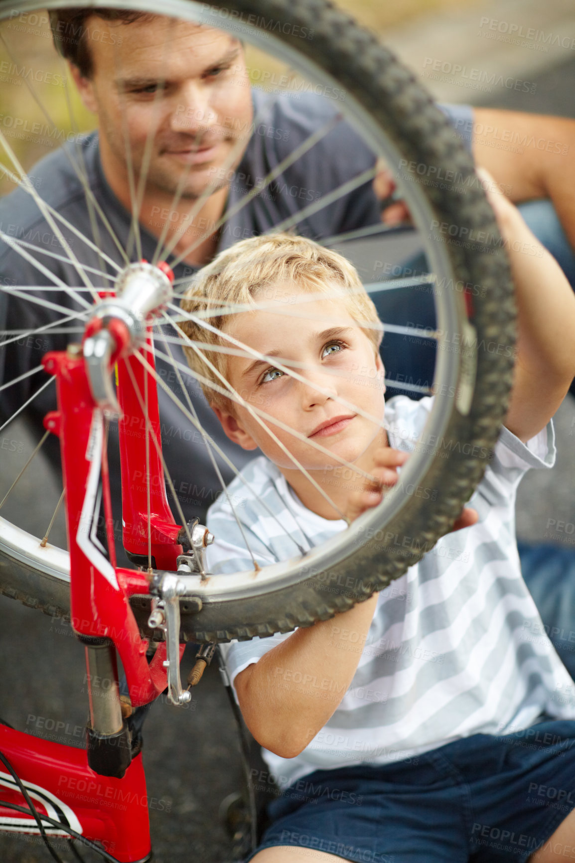 Buy stock photo Bicycle, repair and father help child with bike and learning to fix wheel and parent support kid in vacation or holiday. Smile, development and dad together with son and teaching outdoor skills