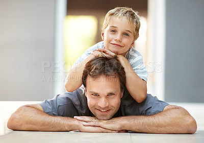 Buy stock photo Smile, portrait and dad with son on floor, cute bonding together with care and love in home. Fun, father and child lying on ground in house with happy relationship, trust and support with man and boy