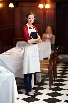 Buy stock photo Cute young waitress standing waiting to serve a customer - portrait