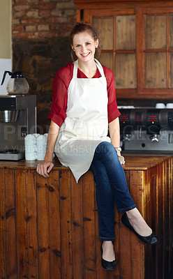 Buy stock photo Woman in portrait, barista at coffee shop and sit on countertop, happy employee in hospitality industry. Female professional in cafe, small business owner and entrepreneur smile with positive mindset