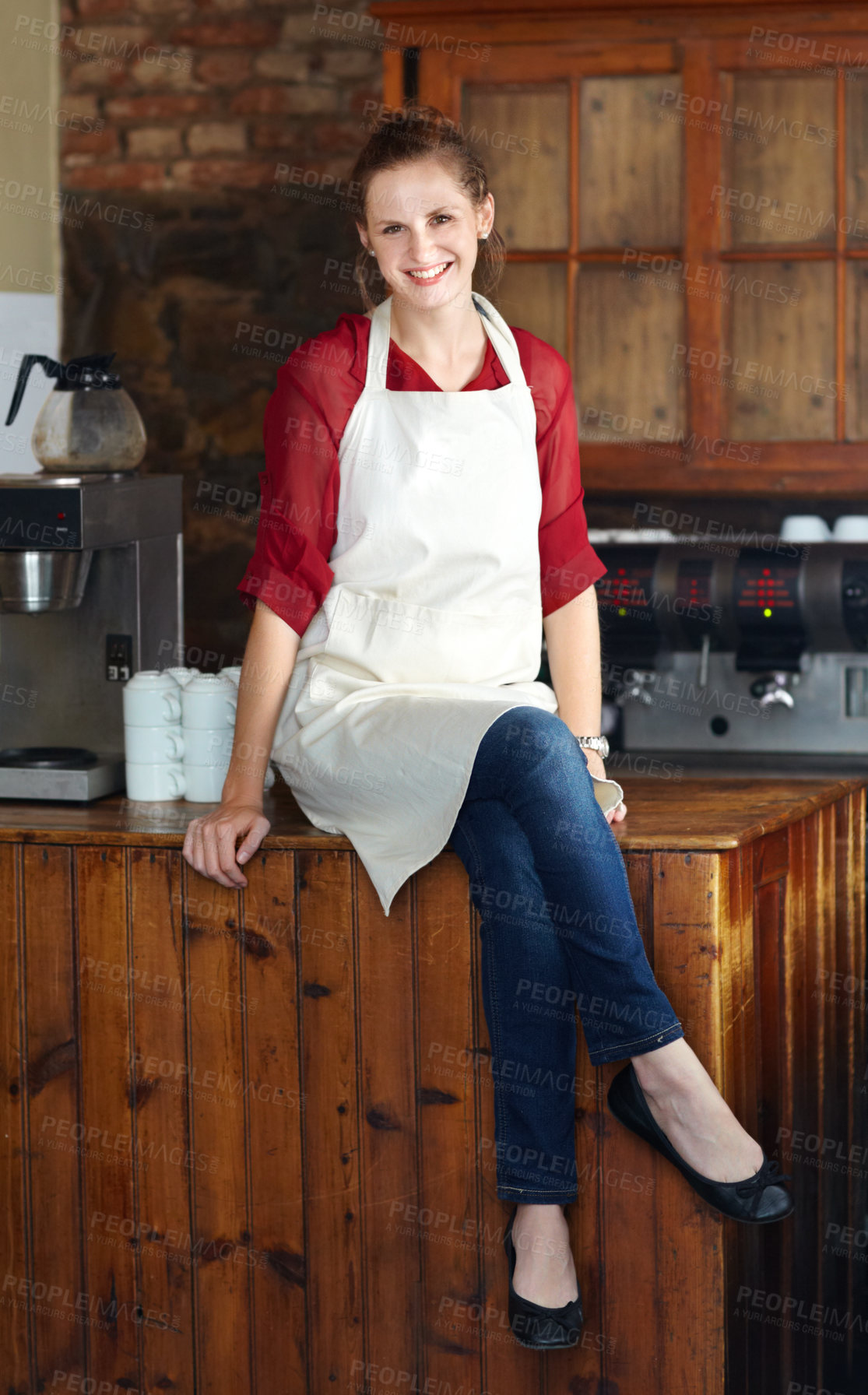 Buy stock photo Woman in portrait, barista at coffee shop and sit on countertop, happy employee in hospitality industry. Female professional in cafe, small business owner and entrepreneur smile with positive mindset
