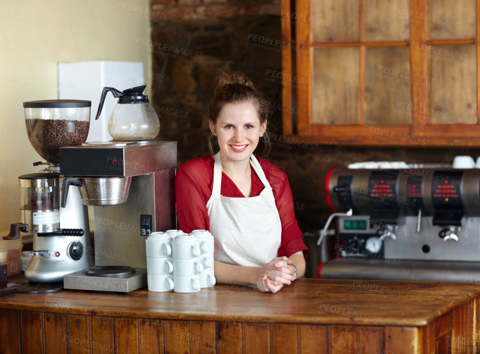 Buy stock photo Pretty young coffee steward behind the counter at work - portrait