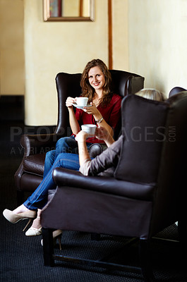 Buy stock photo Coffee, friends sitting in living room on sofa and holding cups with conversation at home. Communication or discussion, company or support and female people or women talking or gossip on armchair