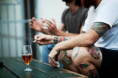 Buy stock photo Shot of young people smoking and drinking