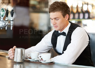 Buy stock photo Coffee, barista and young man waiter in cafe making a latte, espresso or cappuccino at an event. Hospitality, server and male butler preparing a warm beverage in a mug or cup by a bar in restaurant.
