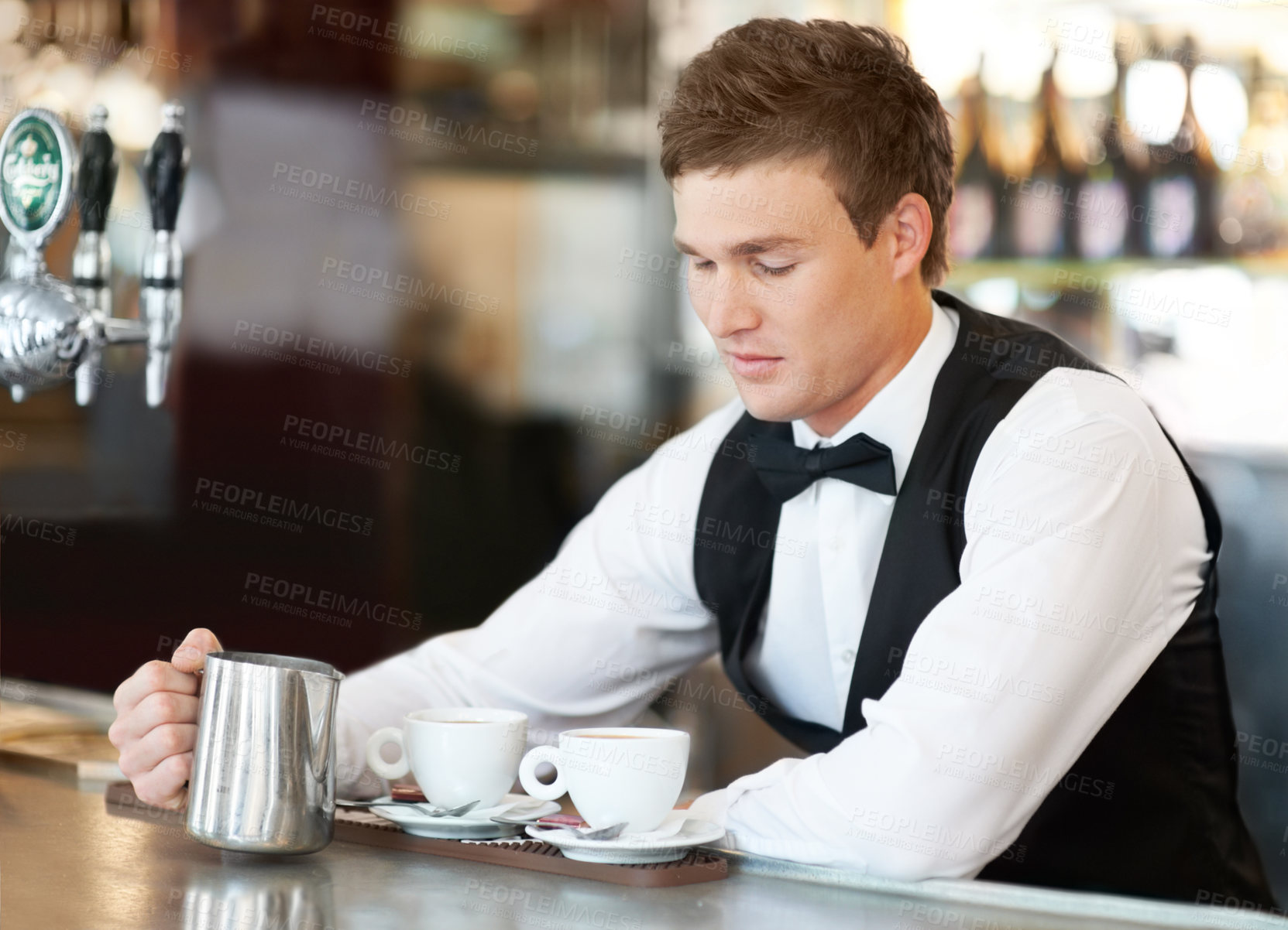 Buy stock photo Coffee, barista and young man waiter in cafe making a latte, espresso or cappuccino at an event. Hospitality, server and male butler preparing a warm beverage in a mug or cup by a bar in restaurant.