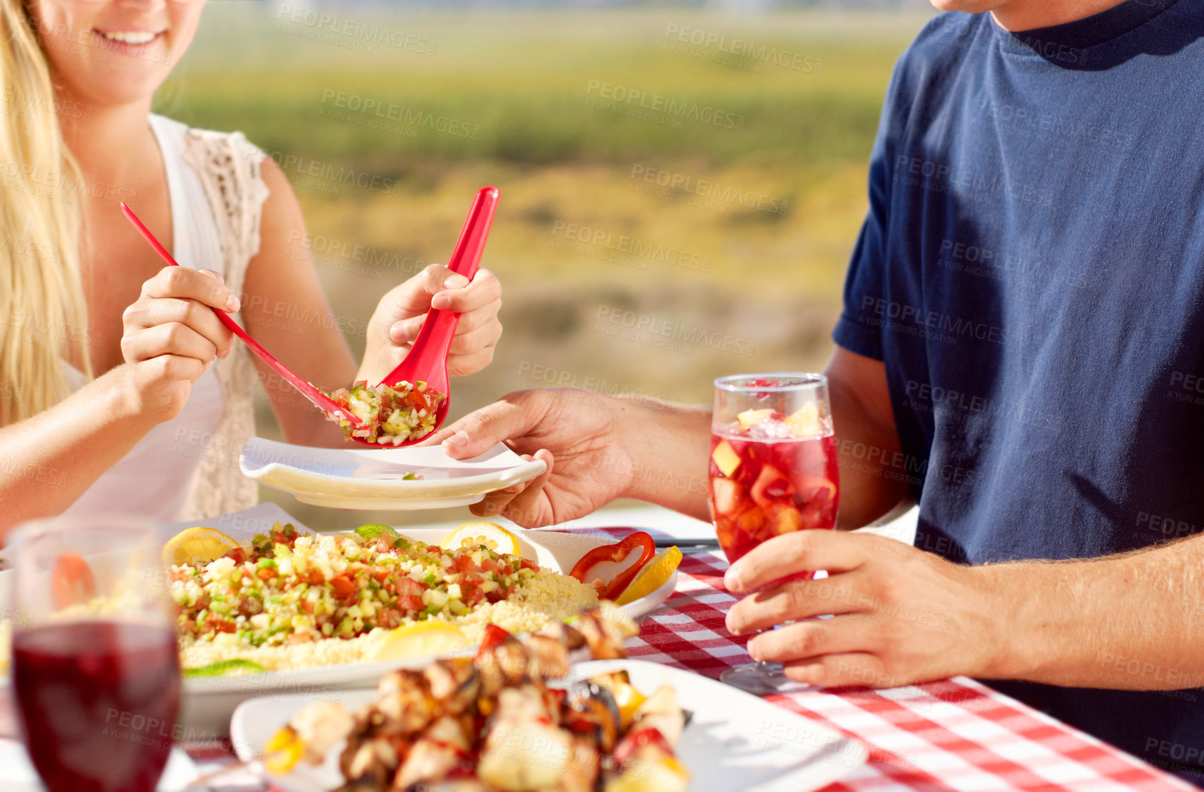 Buy stock photo Cropped image of a young couple eating a meal outside