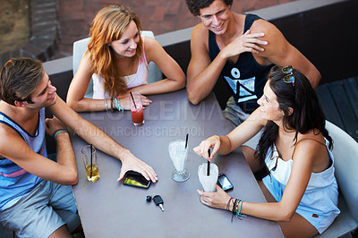 Buy stock photo Group of teens enjoying milkshakes and beverages while at an outdoor restaurant - high angle