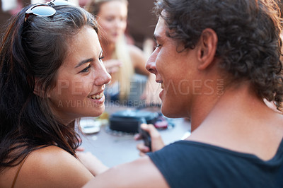 Buy stock photo Young teen couple sharing a romantic moment while out with their friends