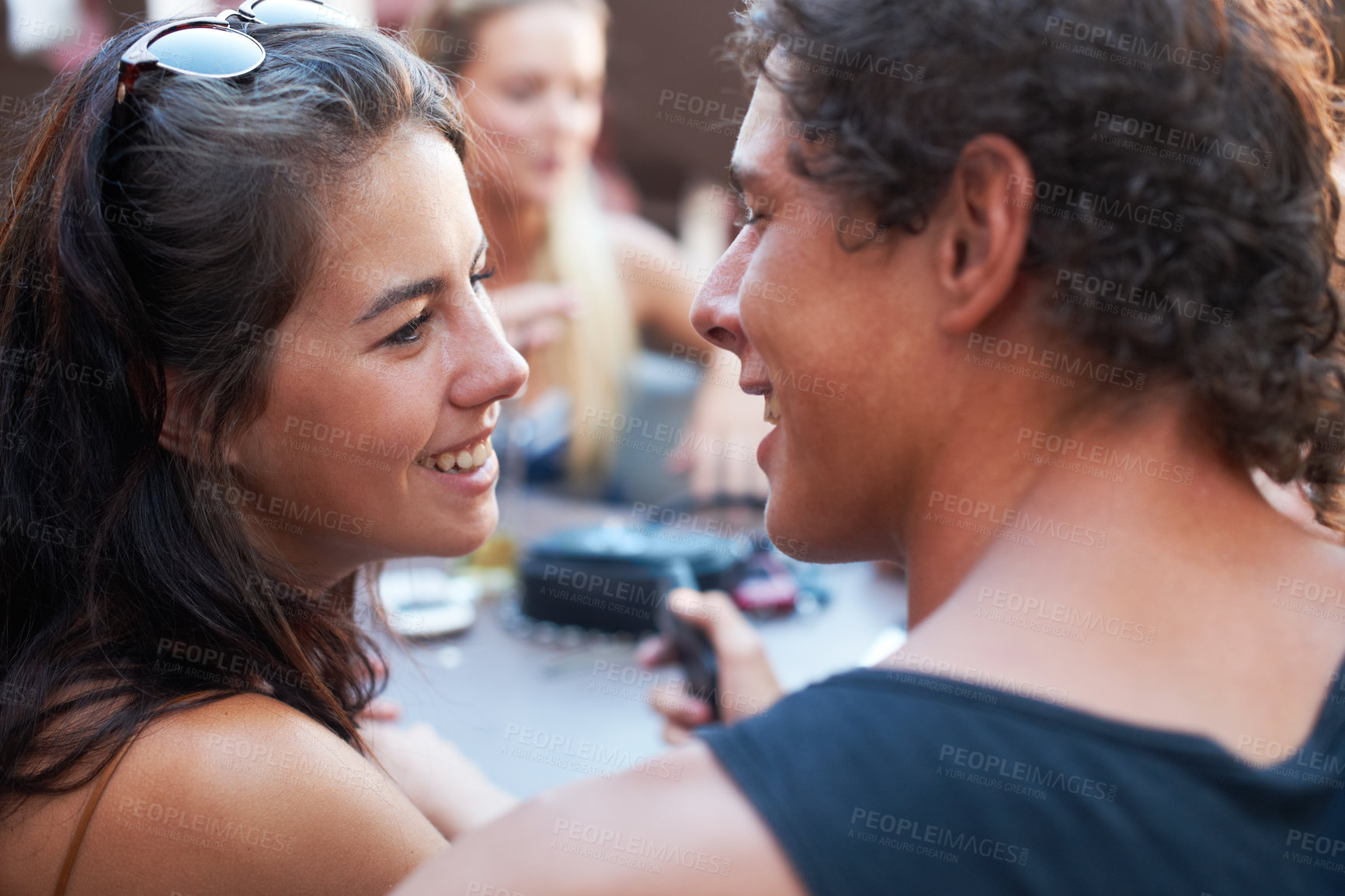 Buy stock photo Young teen couple sharing a romantic moment while out with their friends