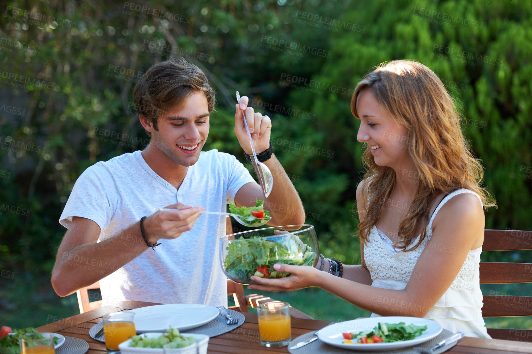 Buy stock photo Happy, friends and food in backyard with salad at a table with hungry young people and smile. Lunch, home garden and group ready for eating with healthy meal together and relax outdoor of a house