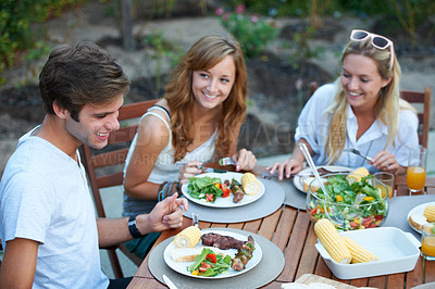Buy stock photo Friends, eating and bbq food in backyard for lunch and happy event with a smile with reunion. Salad, talking and young people outdoor of a home with communication at a table together with a meal