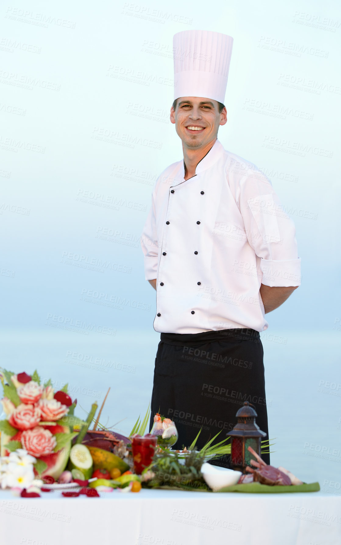 Buy stock photo Happy man, portrait and chef on beach for cooking, resort meal or outdoor catering service. Male person or professional cook smile in fine dining, restaurant or luxury meal, food or water at sea