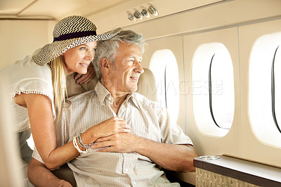 Buy stock photo Smiling senior couple on an airplane looking out the window
