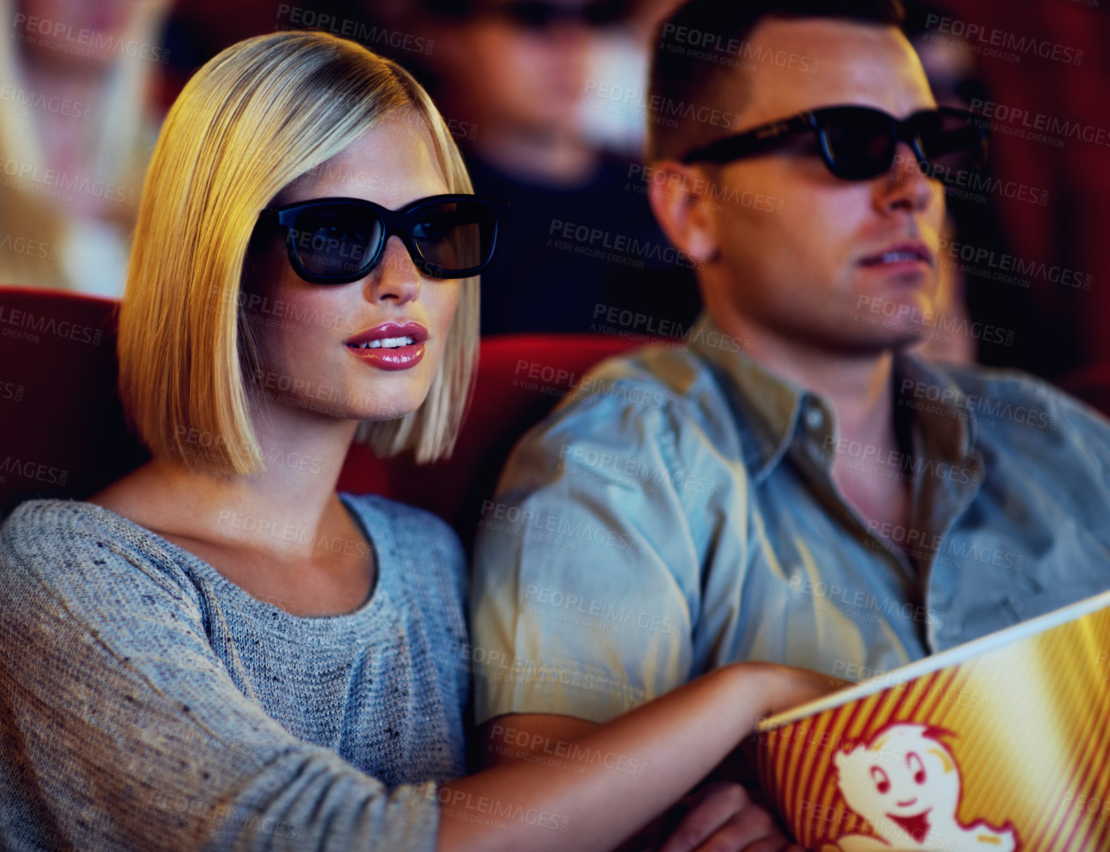 Buy stock photo Couple, 3D movie and cinema of a man and woman sitting and eating popcorn together wearing glasses. People in a relationship watching a film in a theatre for indoor entertainment while having snacks.