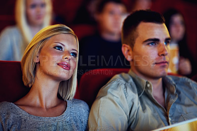 Buy stock photo A cute young couple watching a movie in a cinema together