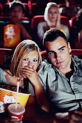 Buy stock photo Cinema, horror and couple with popcorn, watching film and shock on romantic date together. Movie night, man and woman in theater with snacks, scared and sitting in auditorium to relax at show premier