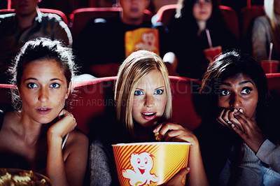 Buy stock photo Wow, popcorn and women in the cinema watching a movie for entertainment while eating a snack. Face, expression and food with shocked young friends in a theater audience to experience a film together