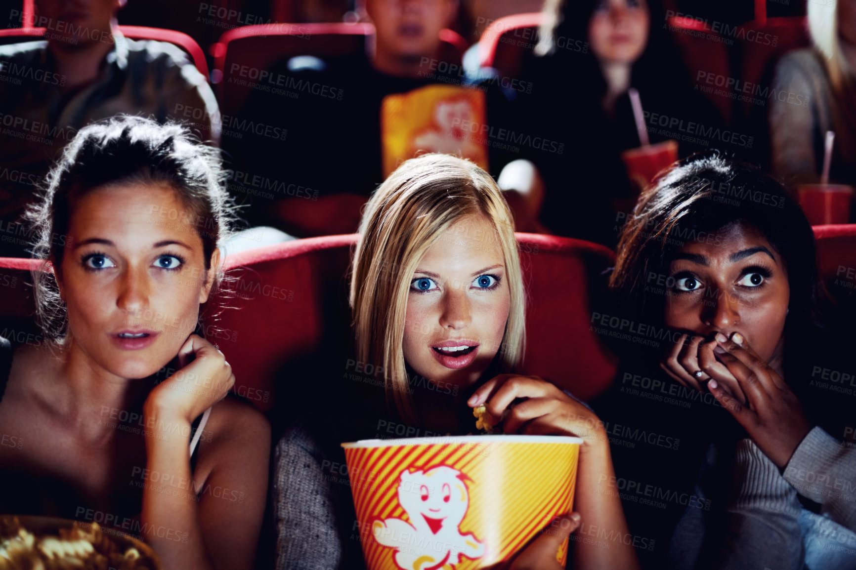 Buy stock photo Wow, popcorn and women in the cinema watching a movie for entertainment while eating a snack. Face, expression and food with shocked young friends in a theater audience to experience a film together