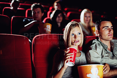 Buy stock photo Seat, popcorn and a couple in the cinema watching a movie for entertainment while on a date. Love, food or romance and young people in a theater audience to experience a film together with a drink