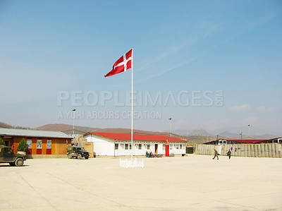 Buy stock photo Denmark, flag and building on landscape with blue sky for military training, bootcamp or government land. Army, base and people outdoor with soldier in countryside for national service and protection