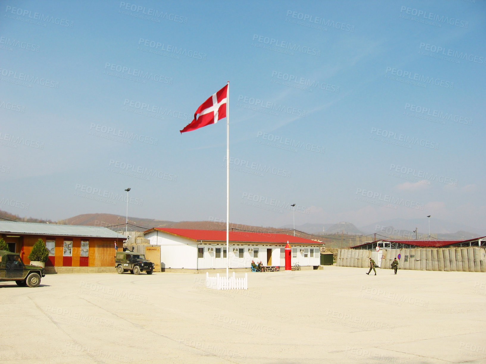 Buy stock photo Denmark, flag and building on landscape with blue sky for military training, bootcamp or government land. Army, base and people outdoor with soldier in countryside for national service and protection