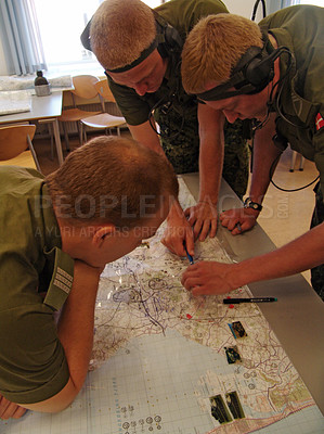 Buy stock photo A group of soldiers discuss strategy over a map