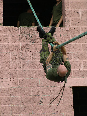 Buy stock photo Army, soldier and training with rope obstacle for fitness, exercise or challenge outdoor upside down. Military, man and climbing with physical workout, mission or bootcamp for survival from building