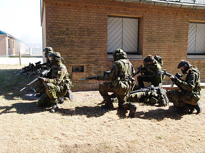 Buy stock photo Soldiers suppressing enemy fire while a comrade lies injured on the ground