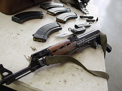 Buy stock photo Gun, rifle and magazines for ammunition of disassembled firearm on table at military base. Closeup of clean army weapon, terrorist or soldier equipment for maintenance, metal or steel barrel on desk