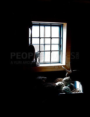 Buy stock photo Dark cabin, interior and light by window in home with gear, tools or fishing equipment, rope or net for storage. Vintage cottage, shed and inside old rustic house, room or abandoned wood architecture