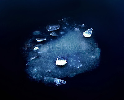 Buy stock photo Ice fragments focused under frozen river water. Dark blue natural background under the deep sea. A top view of the frozen surface of sea water spotted with light and scattered ice shining.