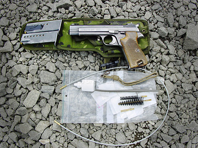 Buy stock photo Military, weapon and handgun with cleaning kit on ground outdoor for service, mission or protection of soldier. Pistol, sniper or gun for maintenance, danger or shooting on battlefield or operation