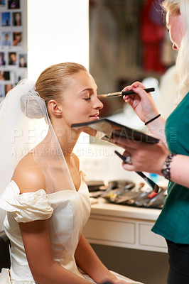 Buy stock photo A make-up artist applying make-up to a bride