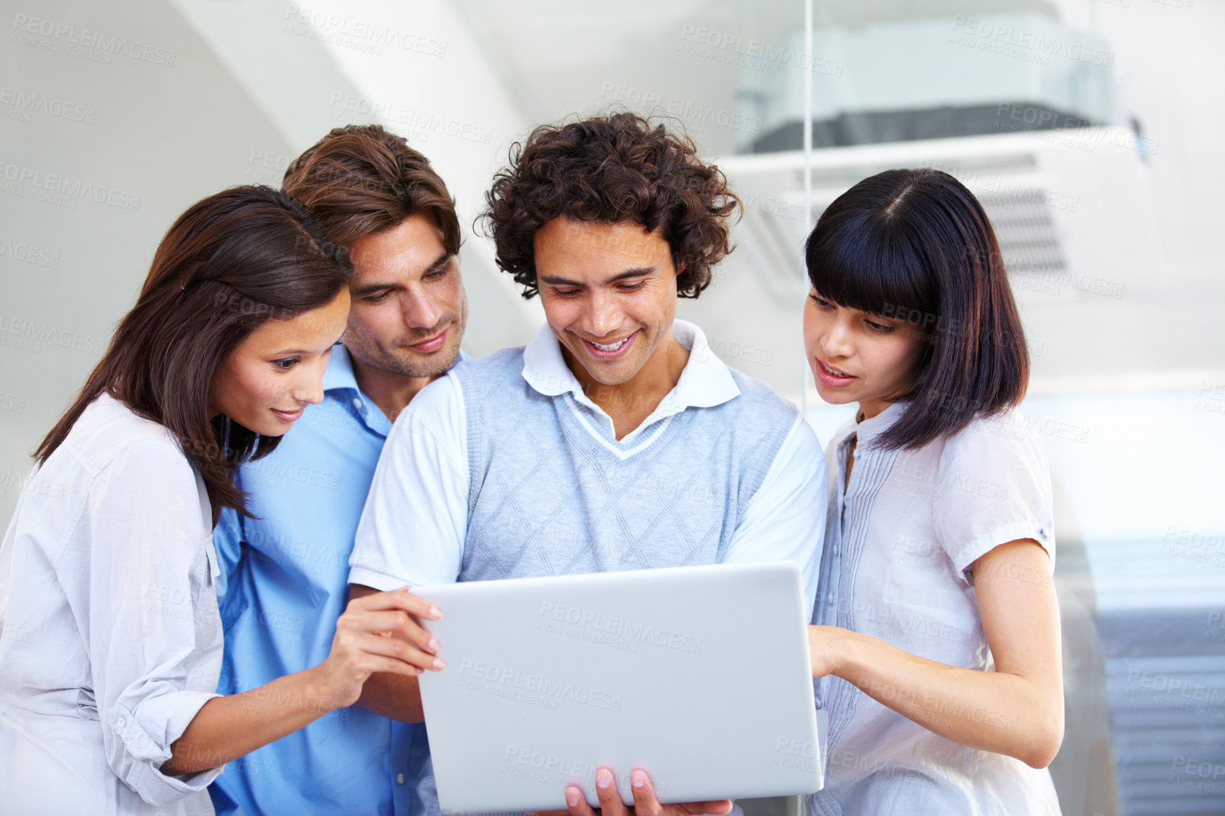 Buy stock photo A group of young entrepreneurs having a business meeting over a laptop