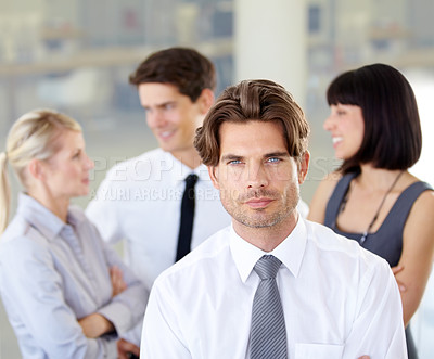 Buy stock photo Portrait of a handsome executive with his arms folded - blurred colleagues in the background