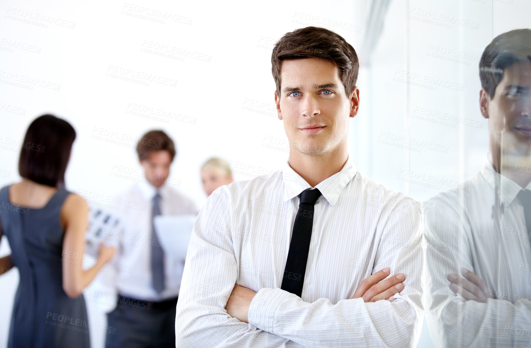 Buy stock photo Portrait of a handsome executive with his arms folded - blurred colleagues in the background