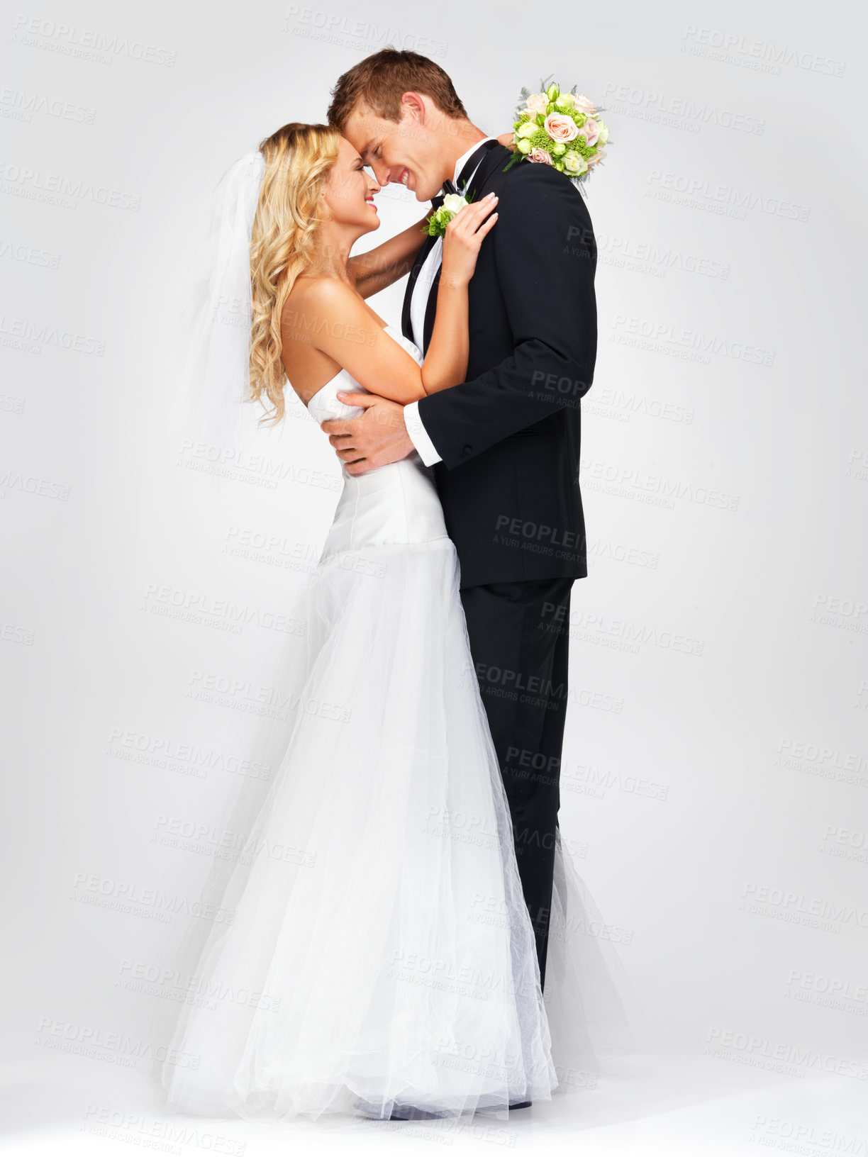 Buy stock photo Wedding smile, couple hug and white background studio portrait. Happy and in love man and beautiful young woman, marriage flowers bouquet in bride hand and lean to kiss husband's cheerful face.