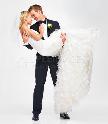 Buy stock photo Attractive young groom holding his bride as they get ready to kiss