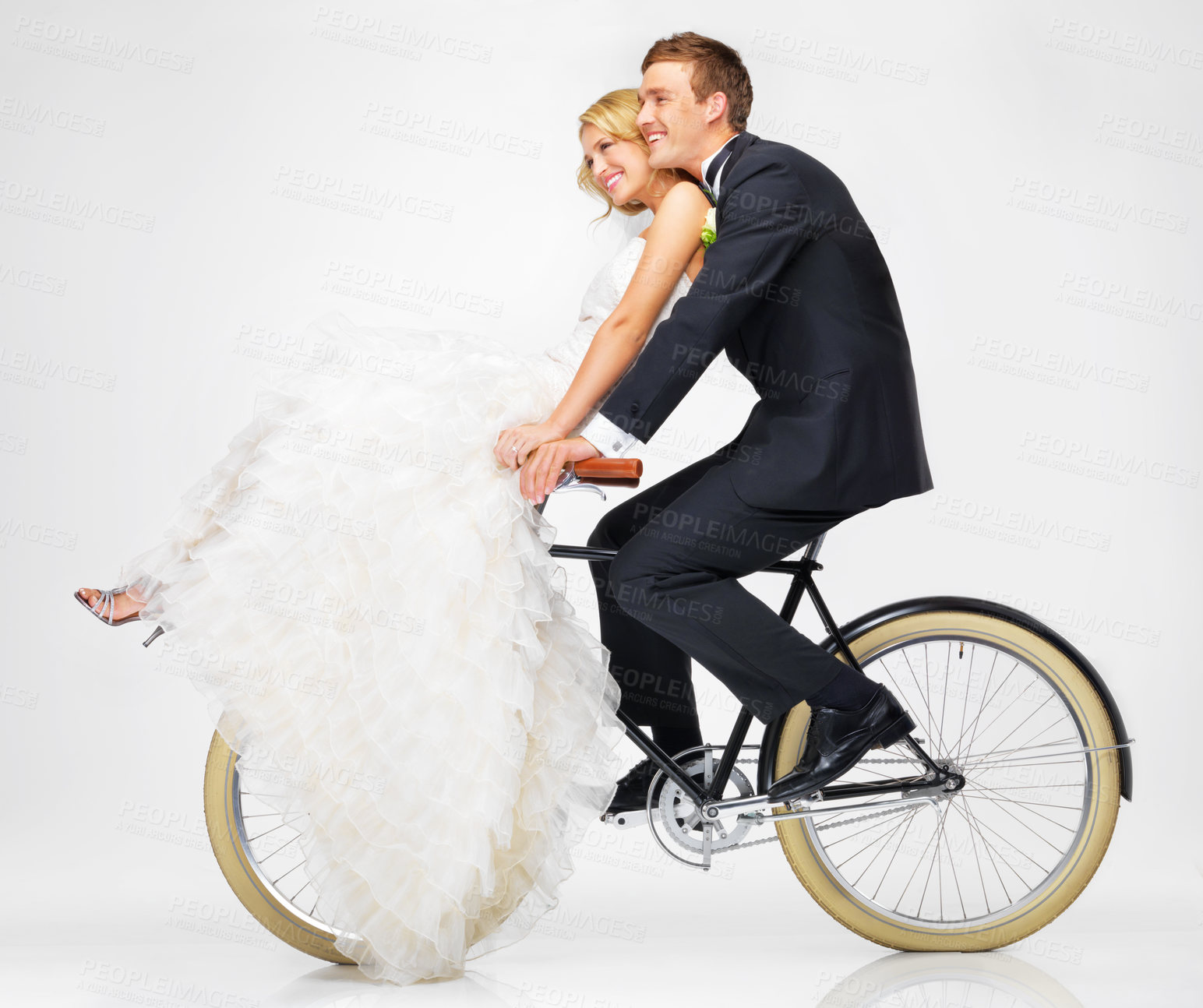 Buy stock photo Happy, wedding and couple on a bicycle against a white background, after getting married together. Love, young bride and groom in dress and suit, cycling on a bike in marriage happiness or bliss 