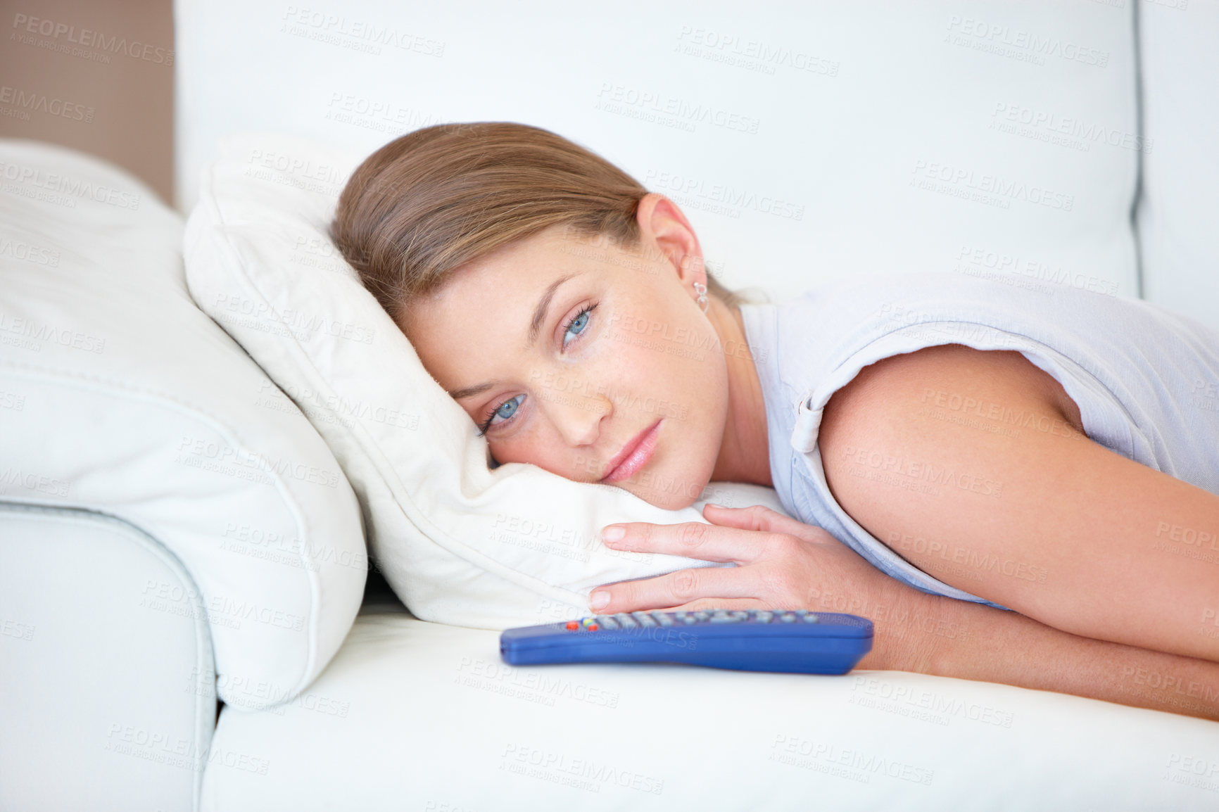Buy stock photo Sad, relax and a woman watching tv on a sofa in the living room of her home for entertainment. Face, depression and remote with a young person streaming a video, movie or film in her apartment
