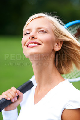 Buy stock photo A young tennis player with the wind in her hair and her racquet on her shoulder