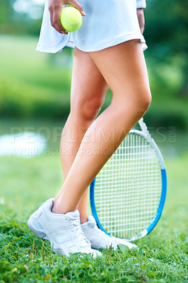 Buy stock photo Cropped view of the legs of a female tennis player with her racquet and ball
