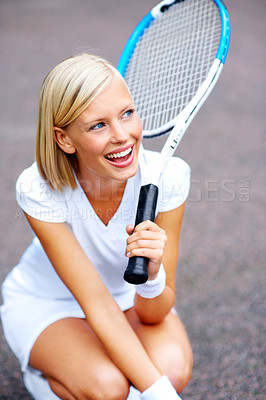Buy stock photo A young tennis player kneeling down and daydreaming of winning her match