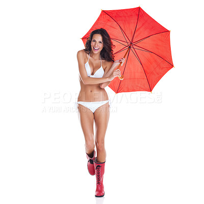 Buy stock photo Studio portrait of a cute young nude woman holding a red umbrella and wearing gumboots while standing against a white background