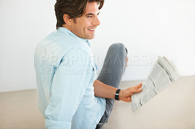 Buy stock photo Newspaper, smile and young man reading information and relaxing on a weekend morning at home. Happy, smart and handsome male person chilling and enjoying a daily paper journal in modern apartment.