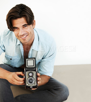 Buy stock photo Happy, camera and portrait of man photographer at a photoshoot for creative work project. Smile, photography and handsome young male person with vintage device for art career by white studio background.