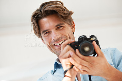 Buy stock photo Production, camera and portrait of man photographer at a photoshoot for creative work project. Happy, photography and handsome young male person with dslr device for art career by white background.